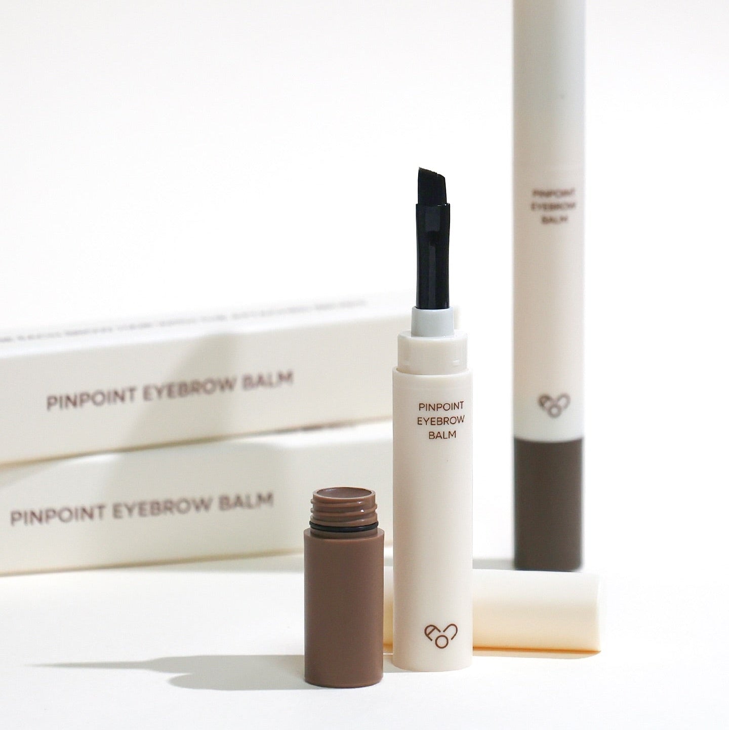 AOU Pinpoint Eyebrow Balm with open tube and brush displayed on a white background, ideal for precise brow styling.