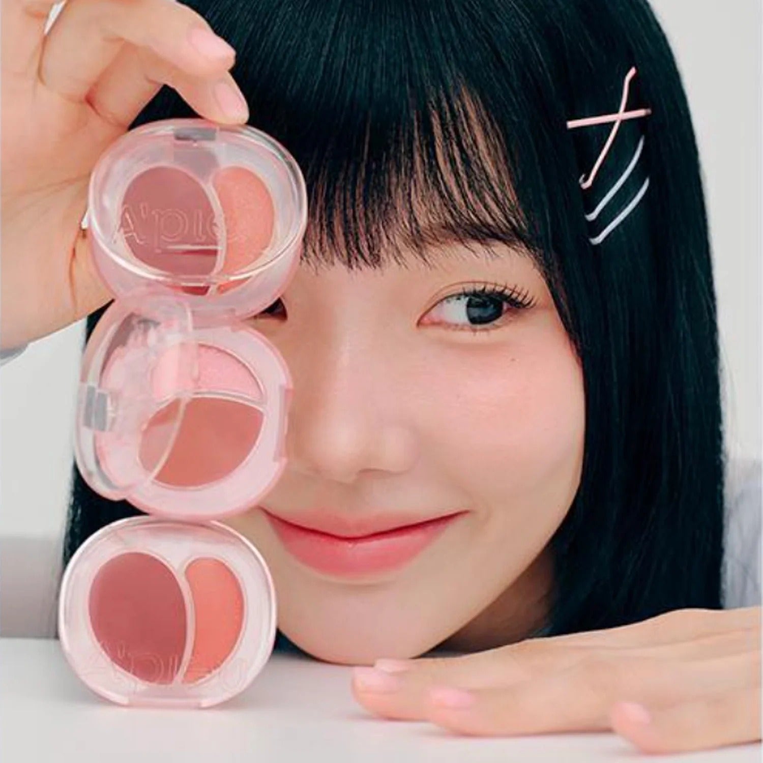 Person showcasing A'PIEU Juicy Pang Mood Blending Lip & Cheek Balm in a playful arrangement.