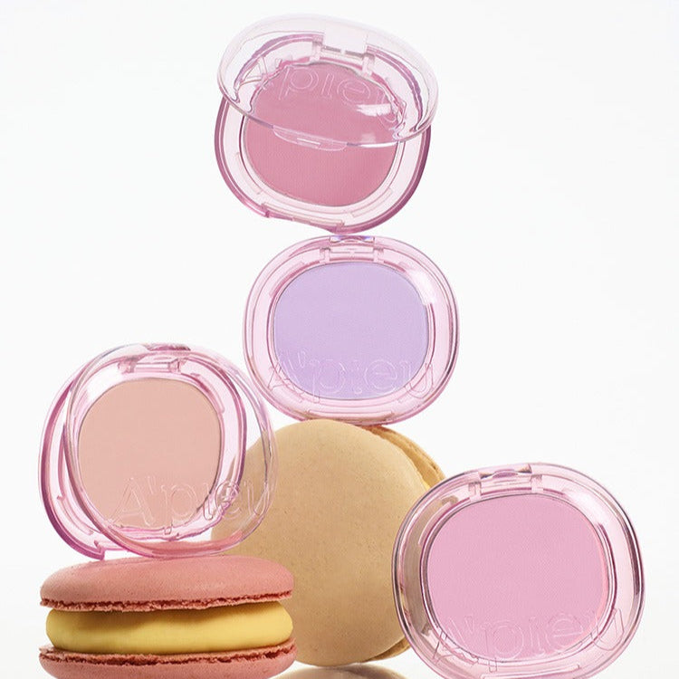 A'PIEU Juicy Pang Pastel Blusher in pink and purple shades, shown with colorful macarons for a playful look.
