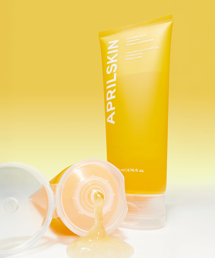 APRILSKIN Calendula Low PH Foam CLeanser in a yellow tube with open cap, showcasing the texture against a matching background