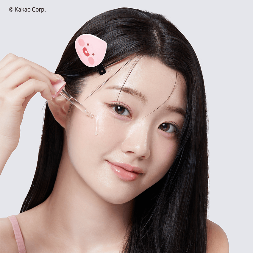 Person applying APRILSKIN Pink Aloe Mucin Serum with dropper on face, showing skincare routine.