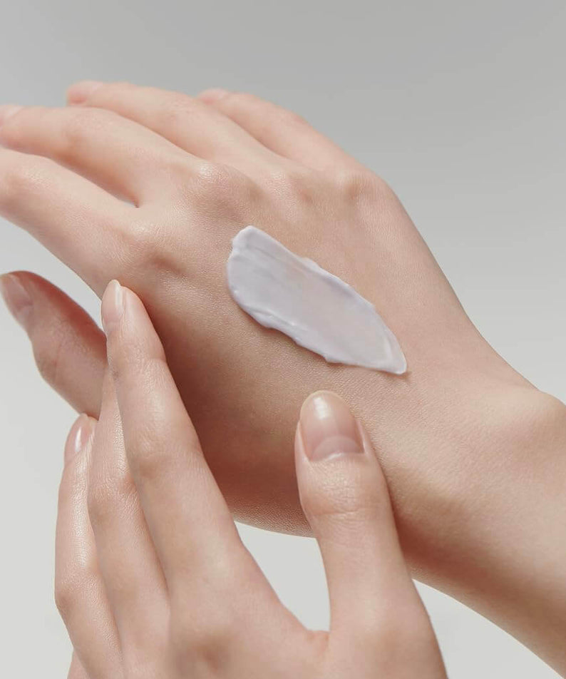 Hand applying ARENCIA Artisan Hysop Blurring Cream 30g on skin