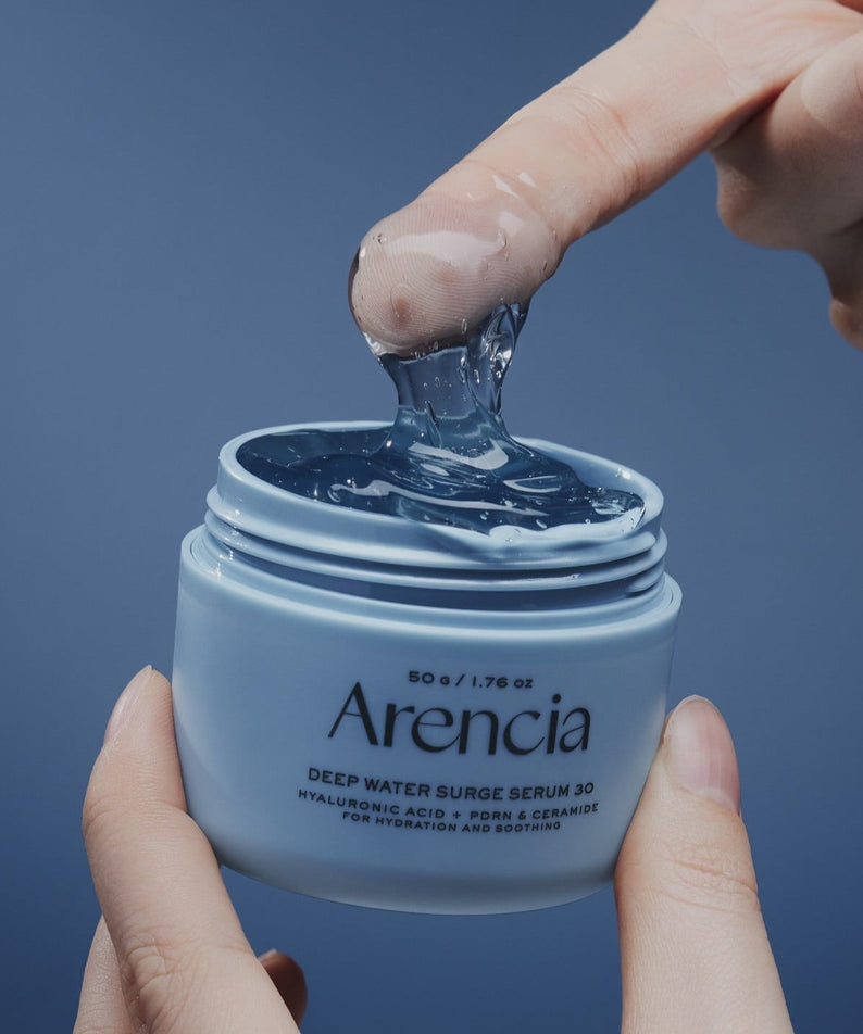 Person using ARENCIA Deep Water Surge Serum 30 50g, showcasing texture and packaging.
