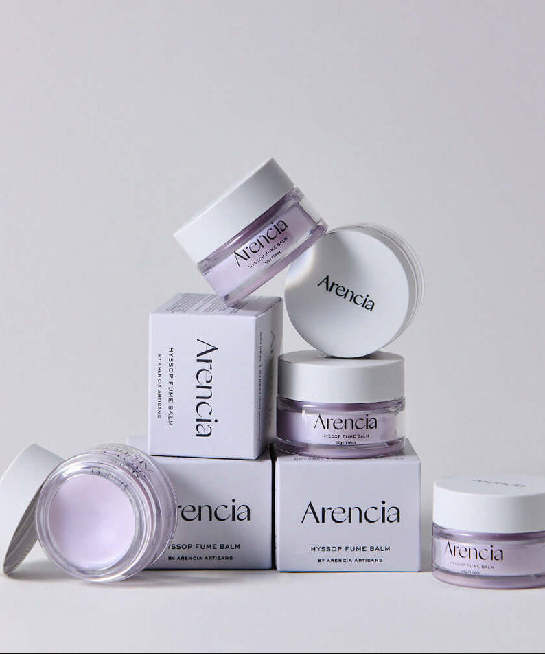 Stacked jars of ARENCIA Hyssop Fume Balm 30g with open and closed lids, showcasing the product's design and packaging.