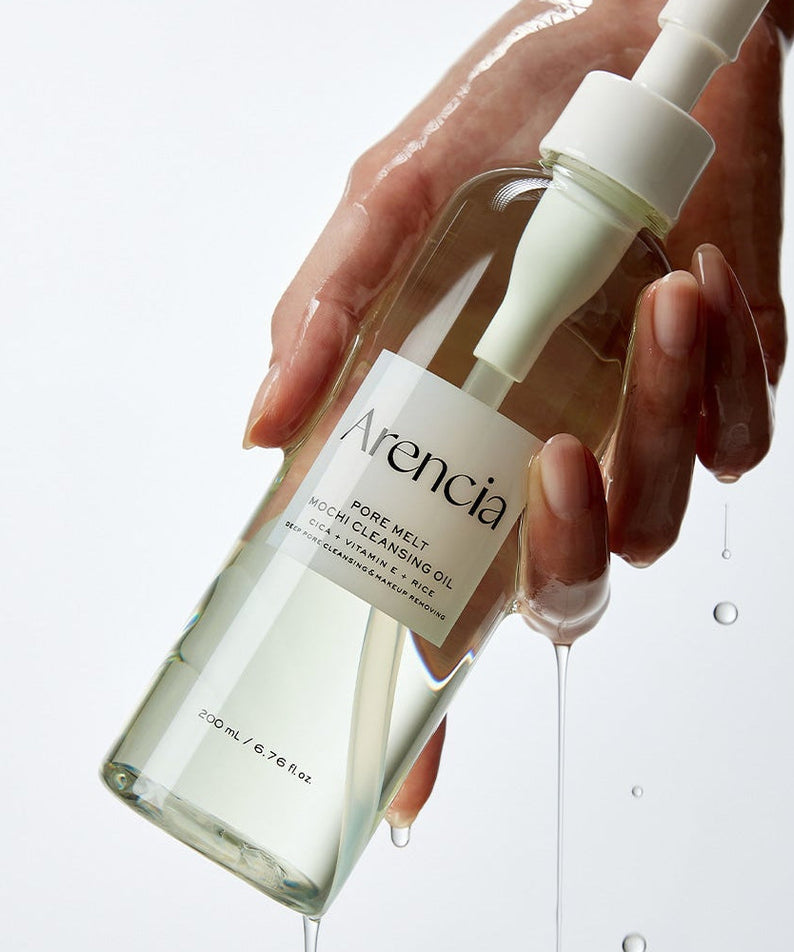 Hand holding ARENCIA Pore Melt Mochi Cleansing Oil 200ml bottle, showcasing product packaging and design.
