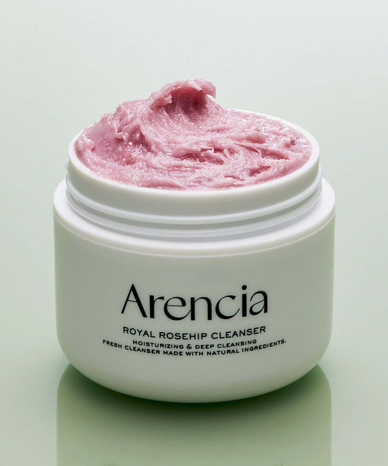 Open jar of ARENCIA Royal Rosehip Fresh Cleanser Rice Soap 120g with pink cream on a green background.