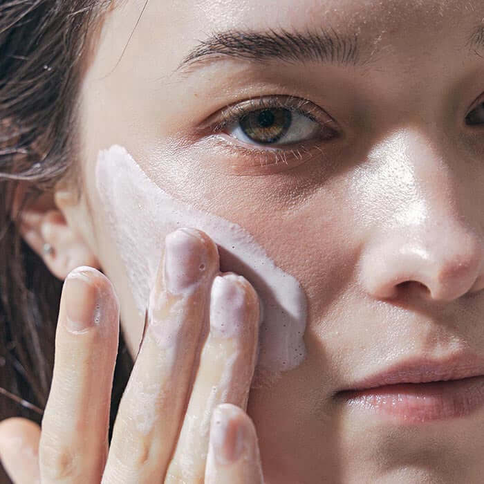 Person applying ARENCIA Royal Rosehip Fresh Cleanser Rice Soap 120g to their face, demonstrating skincare routine.