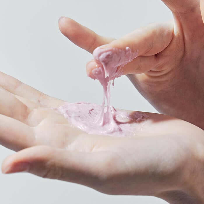 Person applying ARENCIA Royal Rosehip Fresh Cleanser Rice Soap 120g. Close-up of hand with pink creamy cleanser.