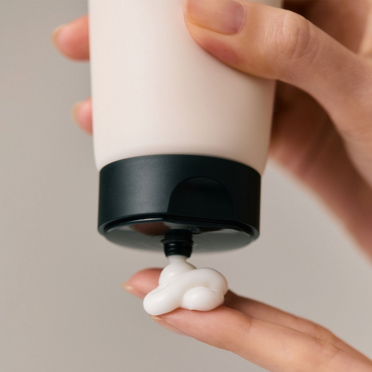 Applying AROMATICA Replenishing Leave-In Treatment Lavender & Patchouli 150ML on finger, close-up hand holding cream tube