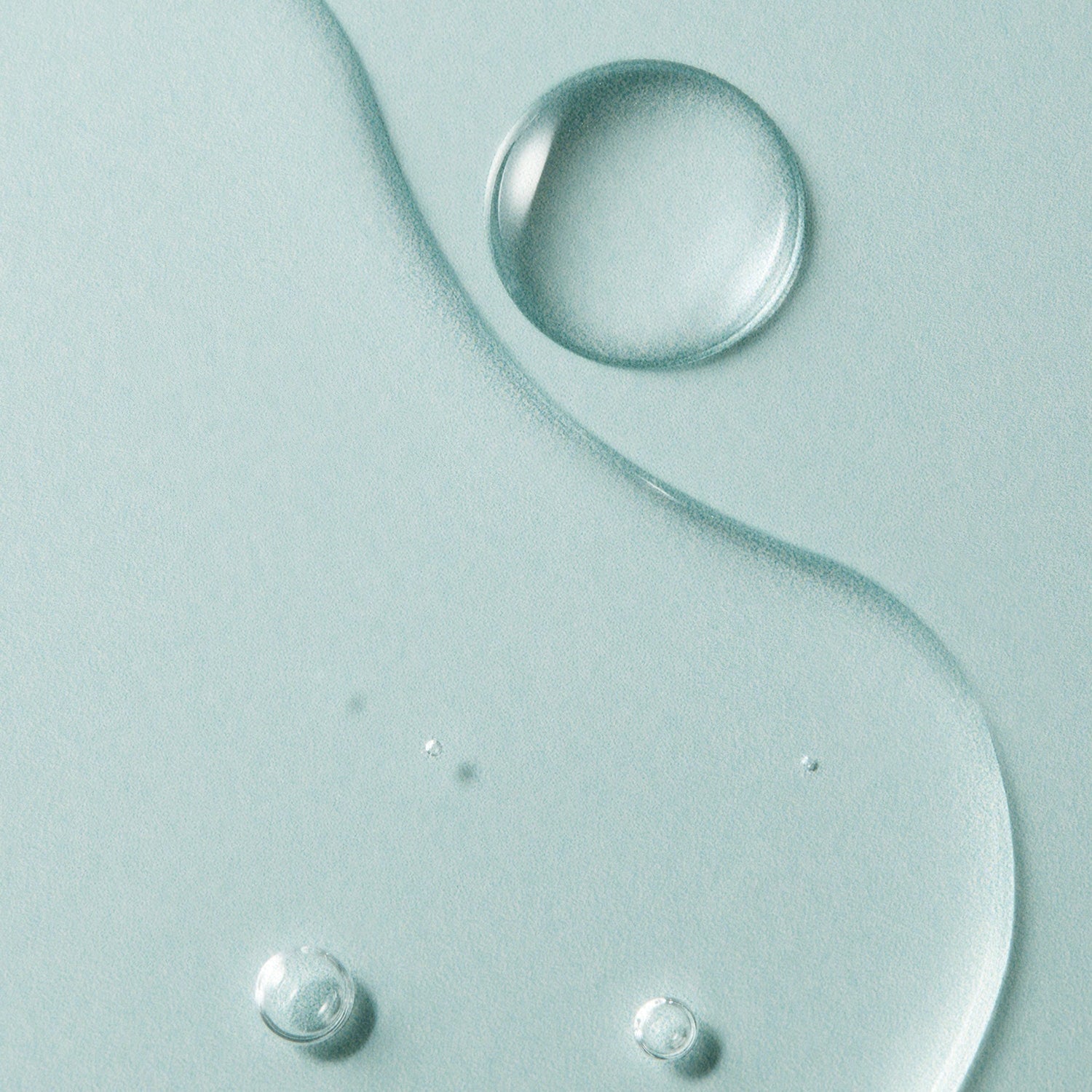 Close-up texture of AROMATICA Super Tea Tree Clarifying Toner 200ML featuring droplets and fluid patterns.