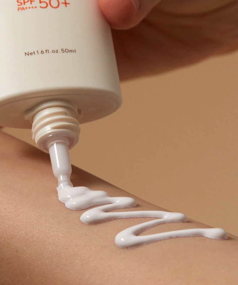 AROMATICA Vitalizing Rosemary Moisture Barrier Sunscreen 50ML being applied to skin, showing texture and SPF 50+ protection
