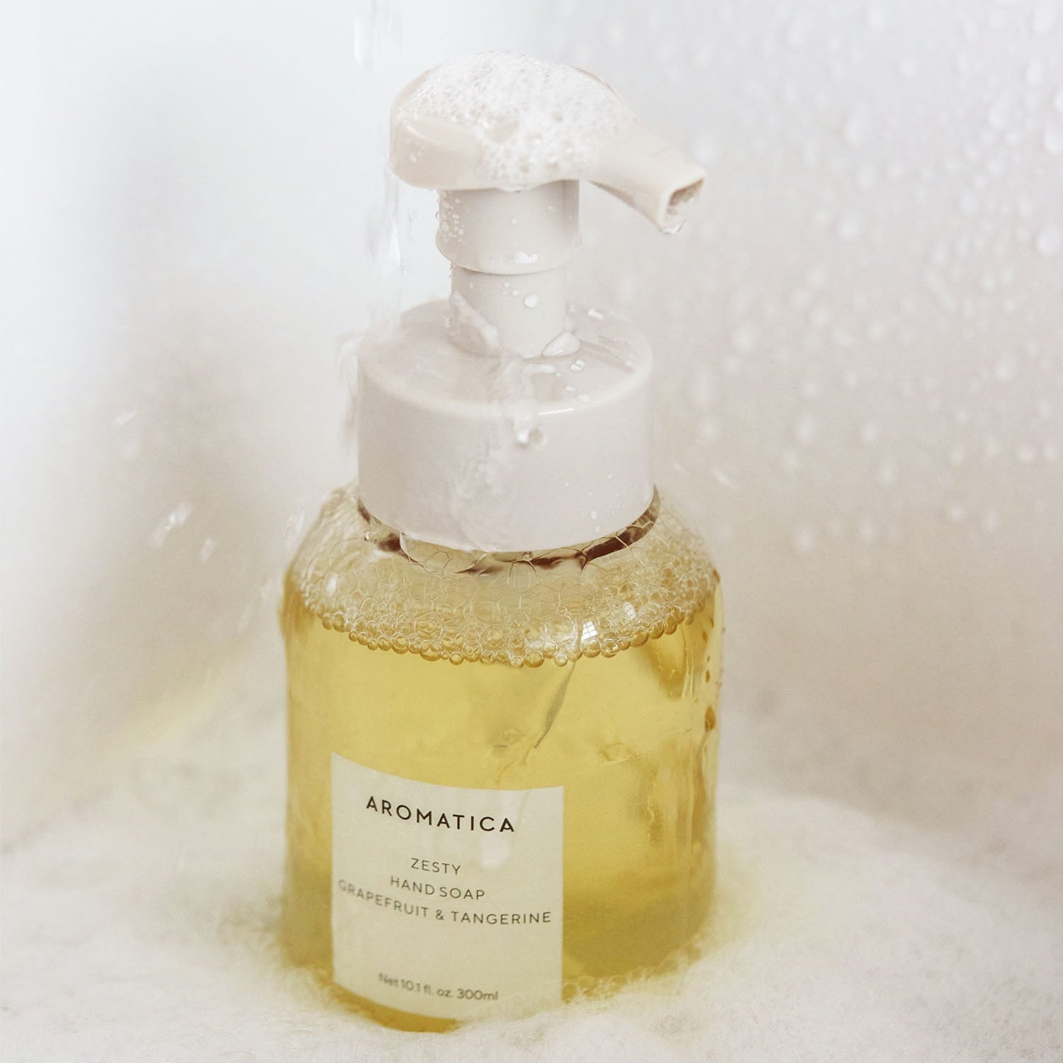AROMATICA Zesty Hand Soap Grapefruit & Tangerine 300ML bottle with foaming pump in a bath setting