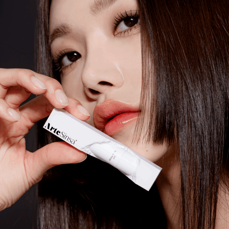 Model holding ARTESINSA Dewy Fit Tint showing lip tint packaging and application