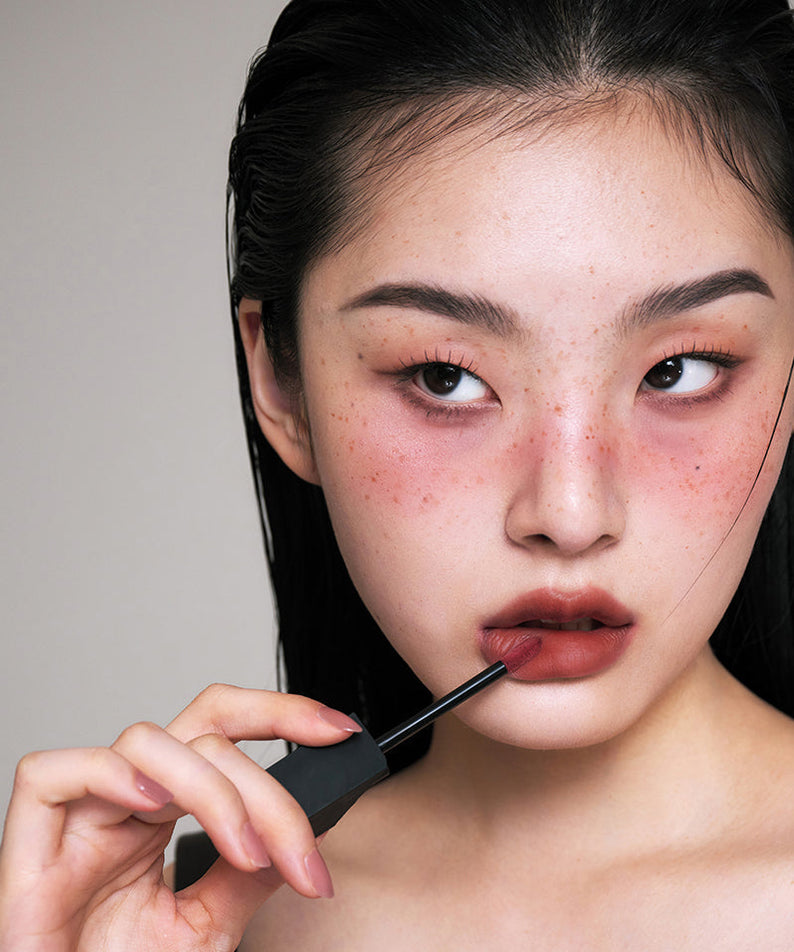 Woman applying ARTESINSA Silky Blur Tints for a flawless lip finish.