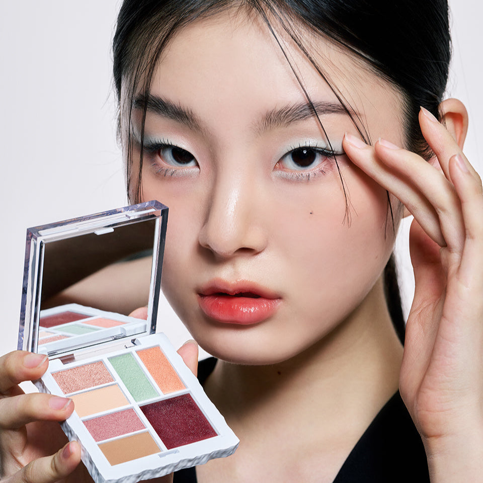 Model holding ARTESINSA Unvoiced Eye Palettes showcasing different eyeshadow colors.