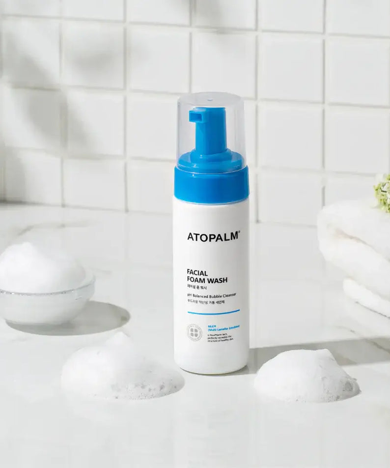 ATOPALM Facial Foam Wash 150ml displayed on a bathroom counter with bubbles and towels, perfect for gentle skin cleansing.