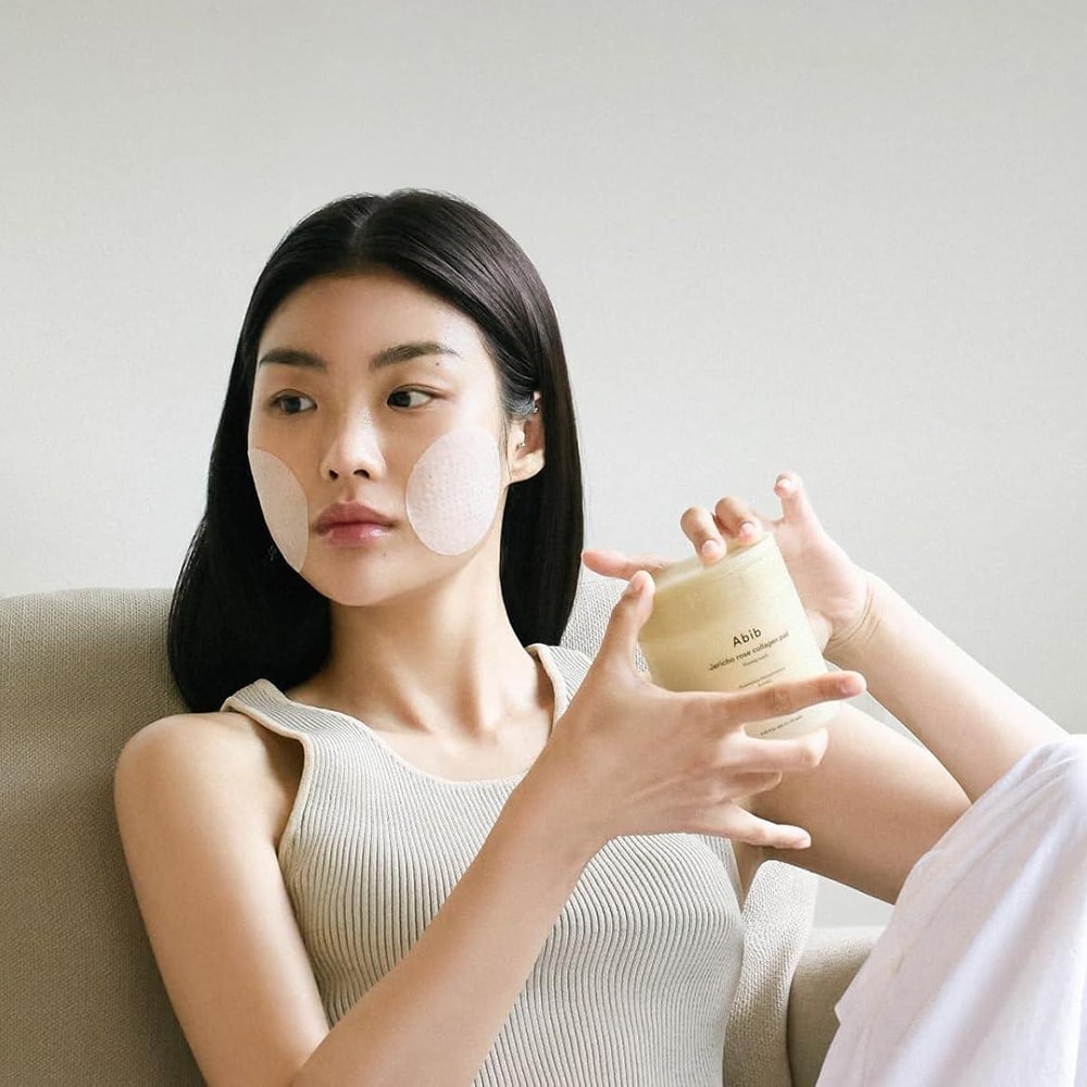 Woman using ABIB Jericho Rose Collagen Pad Firming Touch 60 Pads for skincare routine