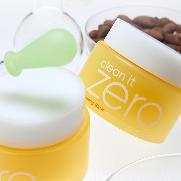 BANILA CO Clean It Zero GInseng Glow Nourishing Cleansing Balm 100ml, yellow jar with a green spatula, shown against a clean backdrop.