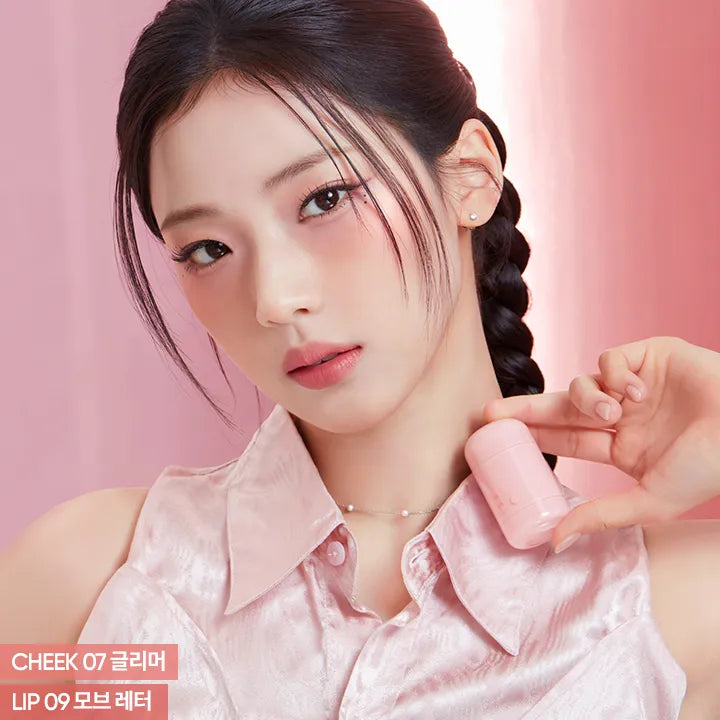 Model wearing BANILA CO Romantic Blush Lip & Cheek with natural makeup look, holding the product.