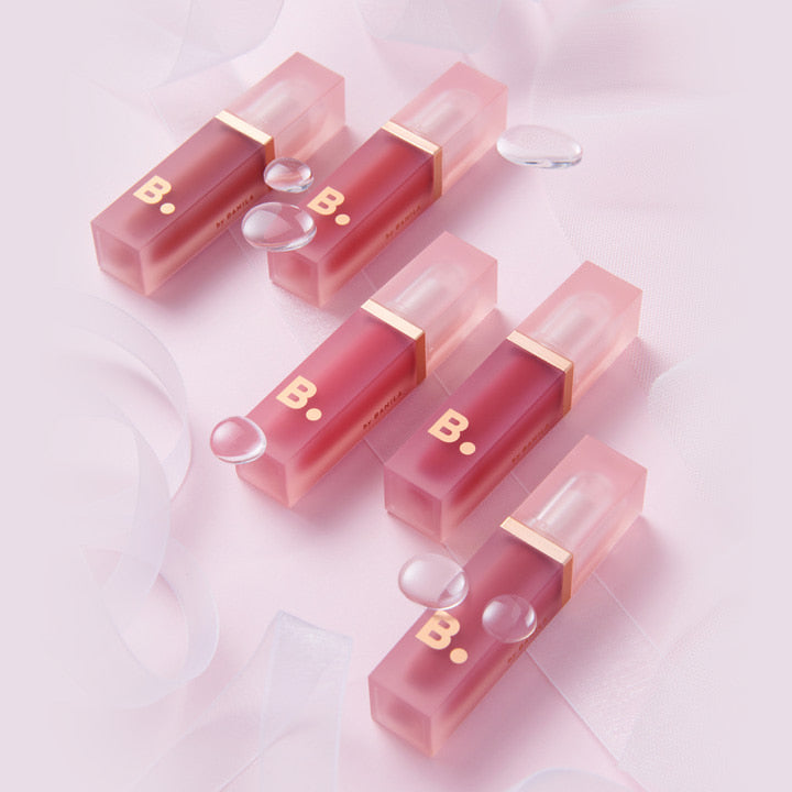 A collection of BANILA CO Water Drop Veil Tint lip tints arranged on a soft pink background, showcasing the product's elegant design.