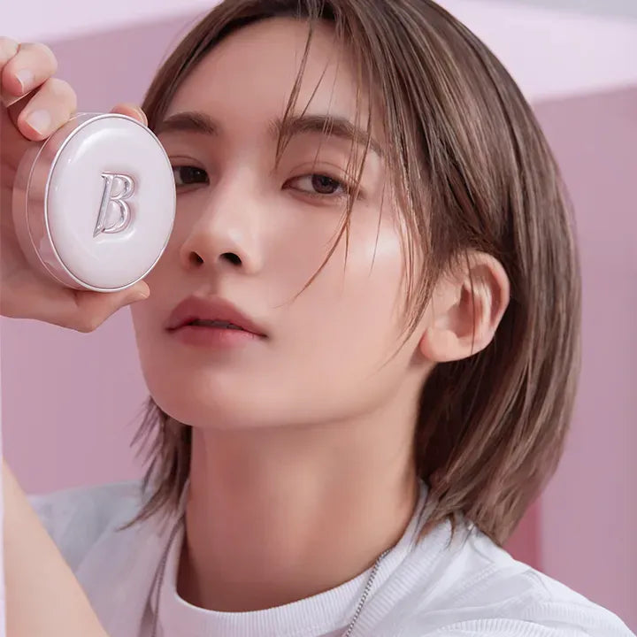 Person holding BANILACO Essence Skin Pink Cushion in hand, showcasing makeup product with pink background and packaging.