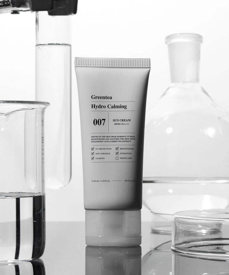 BARULAB Green Tea Hydro Calming Sun Cream tube surrounded by lab glassware