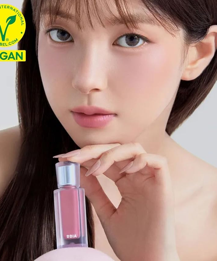 Model holding BBIA Last Velvet Tint in a vegan-certified packaging