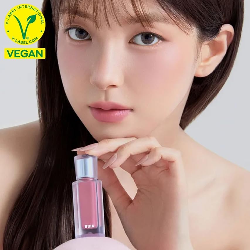 Model holding BBIA Last Velvet Tint in a vegan-certified packaging