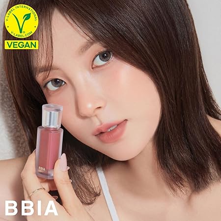 BBIA Last Velvet Tint held by model with vegan label, showcasing the product's color and packaging.
