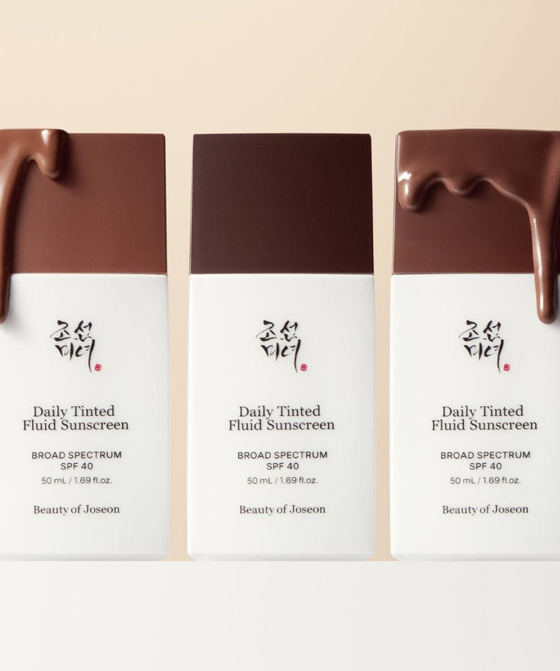 Three bottles of BEAUTY OF JOSEON Daily Tinted Fluid Sunscreen 50ml with brown tinted fluid on top, SPF 40, broad spectrum protection.