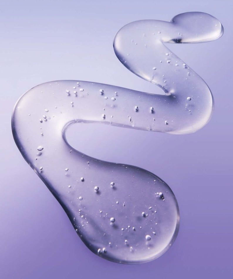 Texture of BELIF Numero 10 Essence 75ml skincare product with purple hue and droplets