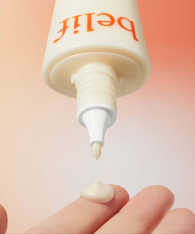 Close-up of BELIF Super Drops Glow Serum 50ml being dispensed onto a fingertip with gradient background.