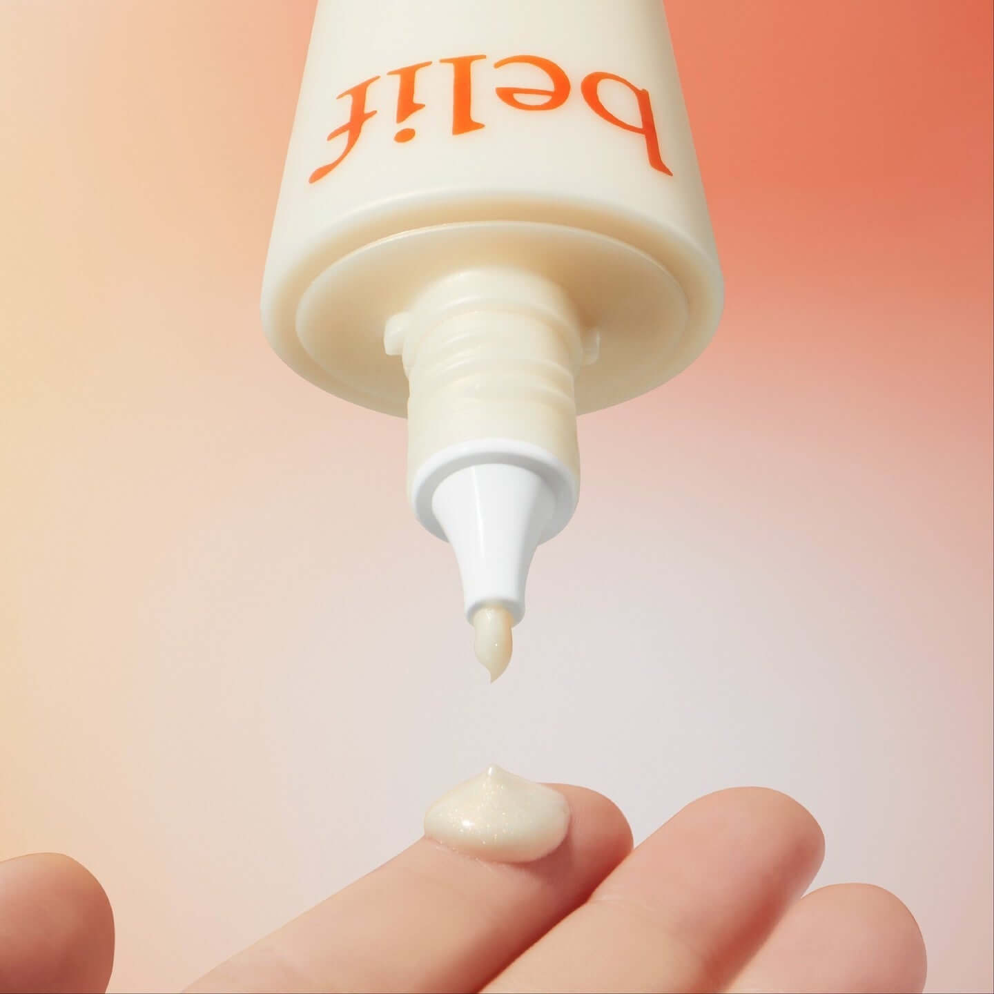 Close-up of BELIF Super Drops Glow Serum 50ml being dispensed onto a fingertip with gradient background.