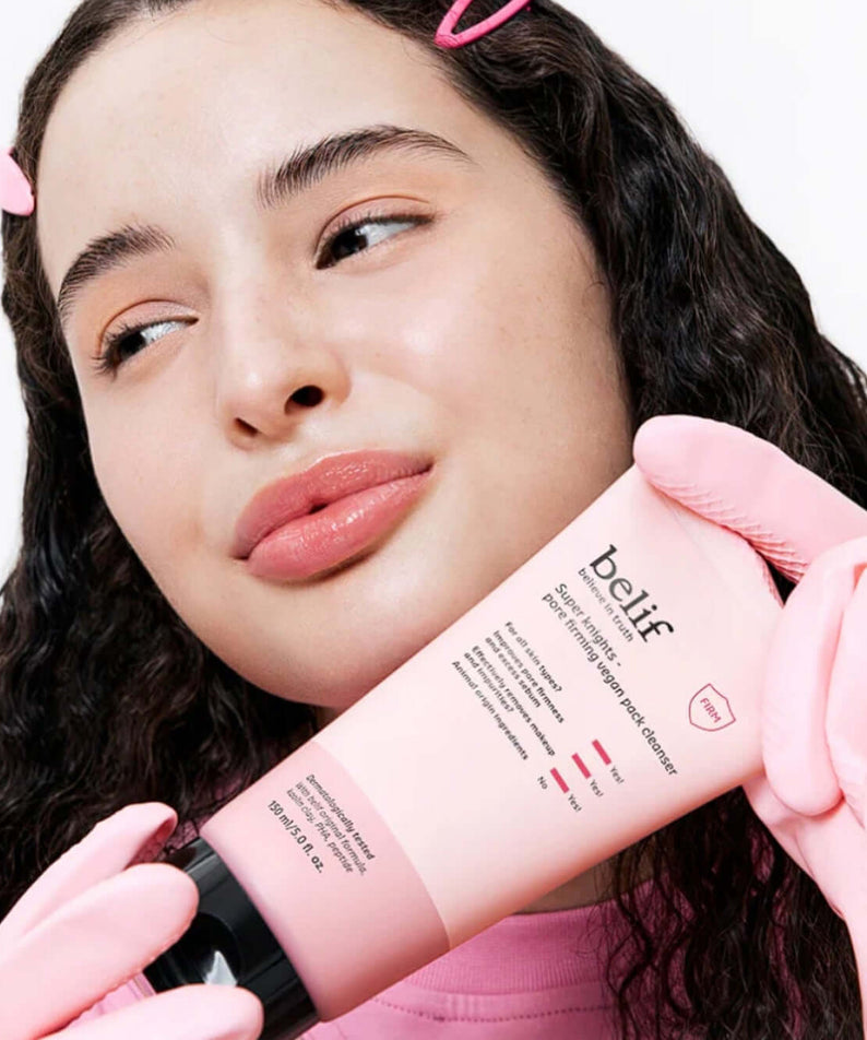 Woman holding BELIF Super Knights Pore Fiming Vegan Pack Cleanser 150ml, highlighting the skincare product in a pink package.