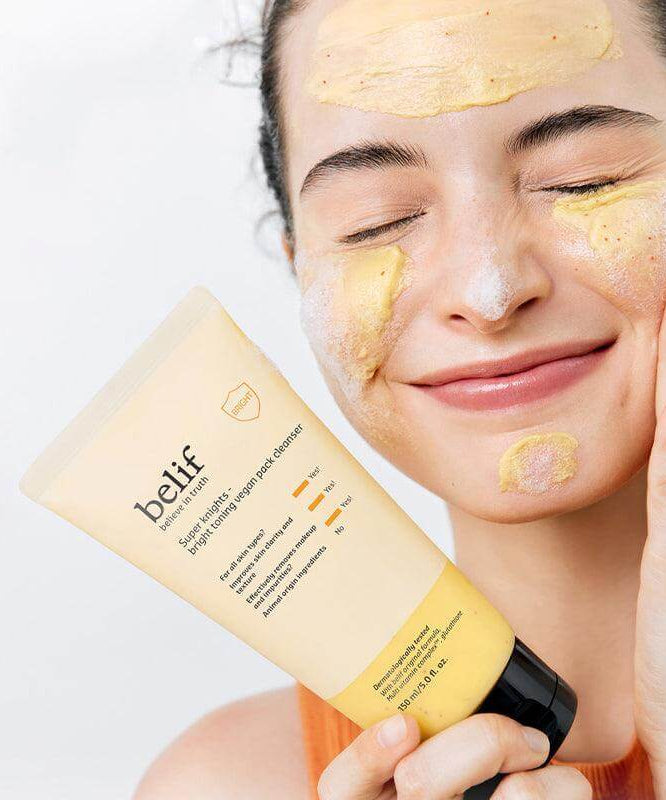 Woman applying BELIF Super Knights bright Toning Vegan Pack Cleanser 150ml to her face, showing the product in use.