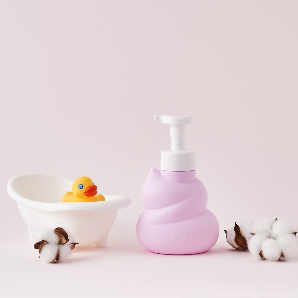 BELLBOY STUDIO Hippong Bubble Butt Cleanser bottle next to small duck tub and cotton balls on a soft pastel background