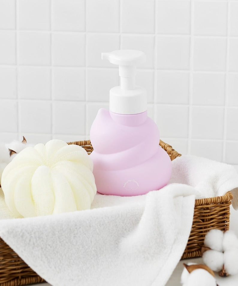 BELLBOY STUDIO Hippong Bubble Butt Cleanser bottle in a wicker basket with cotton and towels, showcasing bathroom decor and product display.