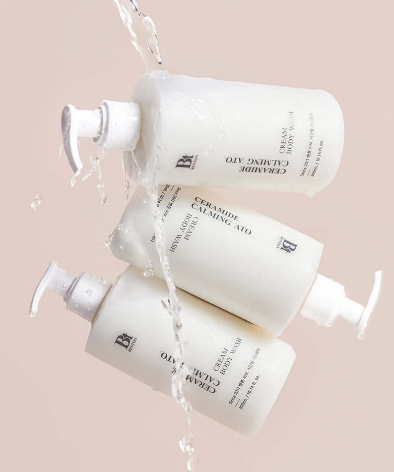 BENTON Ceramide Calming Ato Cream Body Wash 300ml bottles with water pouring over them, showcasing packaging and texture.