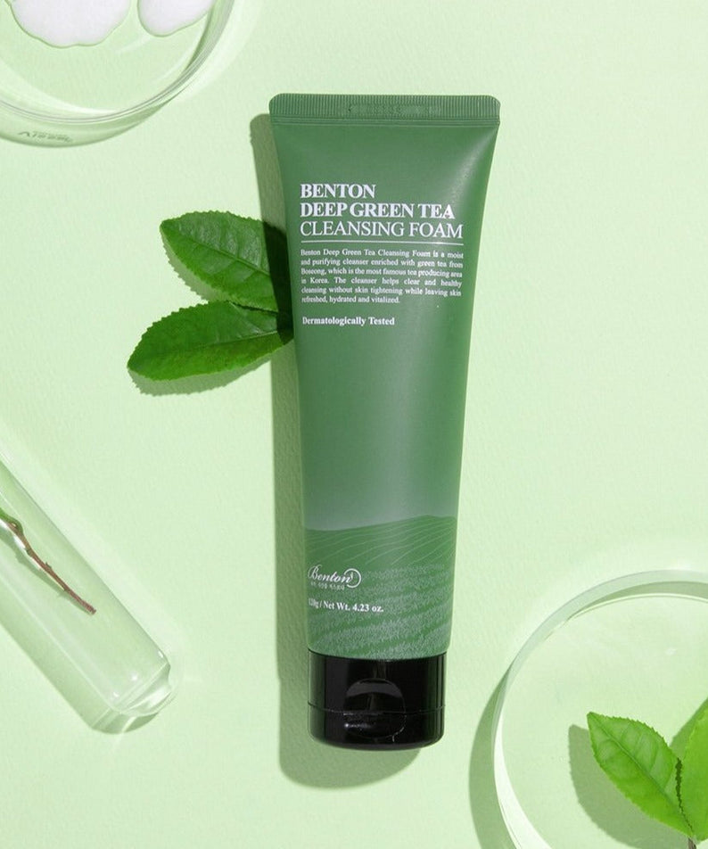 BENTON Deep Green Tea Cleansing Foam 120g tube on light green background with green tea leaves and test tubes.