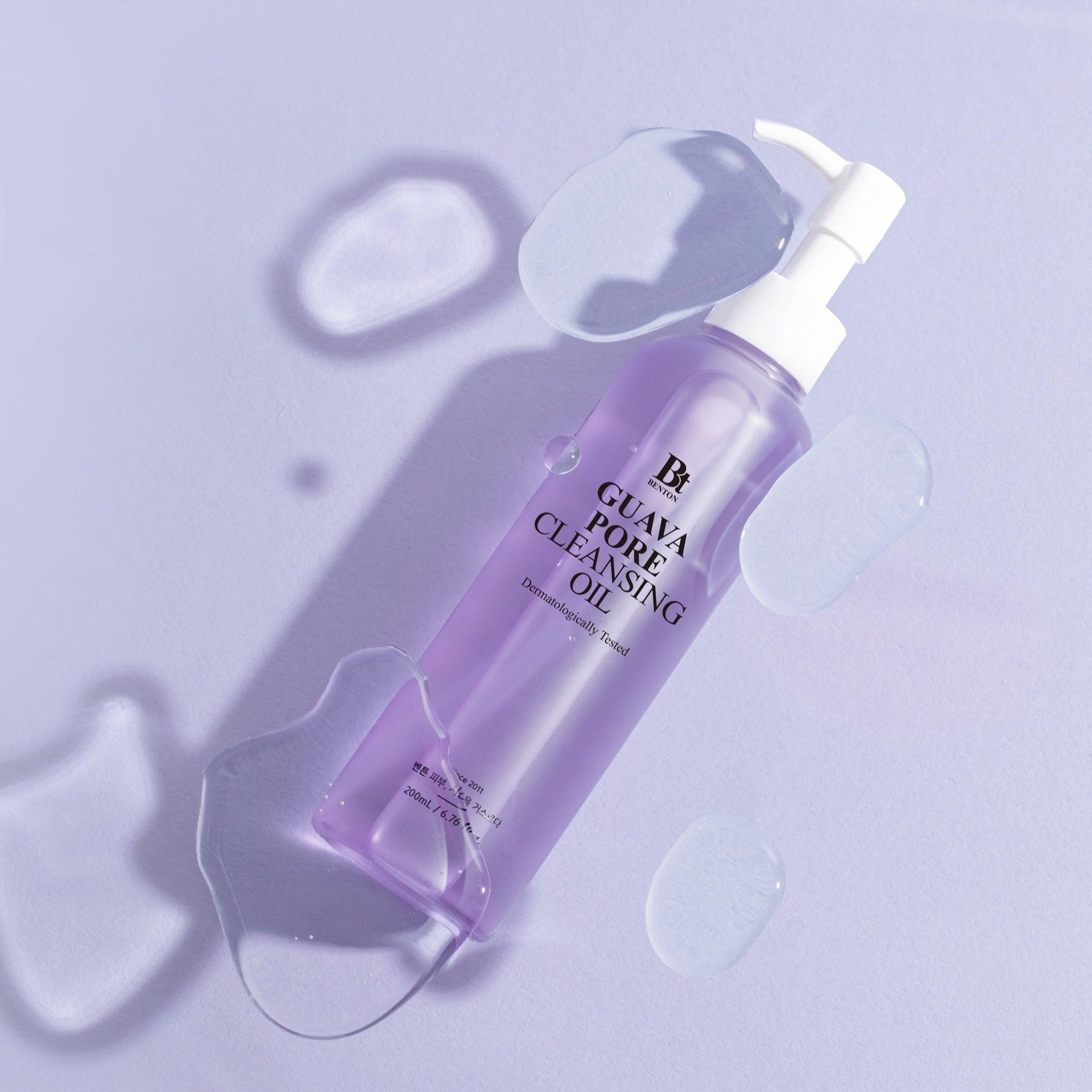 BENTON Guava Blackhead Pore Cleansing Oil 200ml bottle with purple liquid and pump on a light purple background