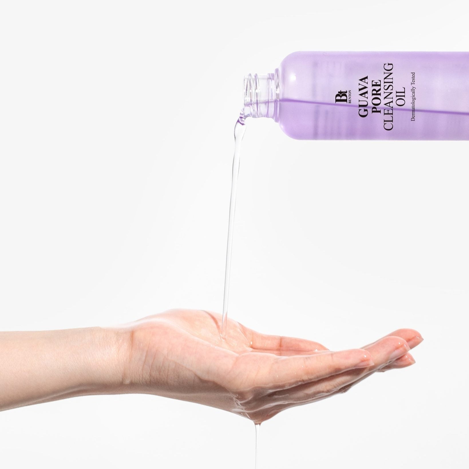 BENTON Guava Blackhead Pore Cleansing Oil 200ml being poured onto a hand for skincare demonstration.