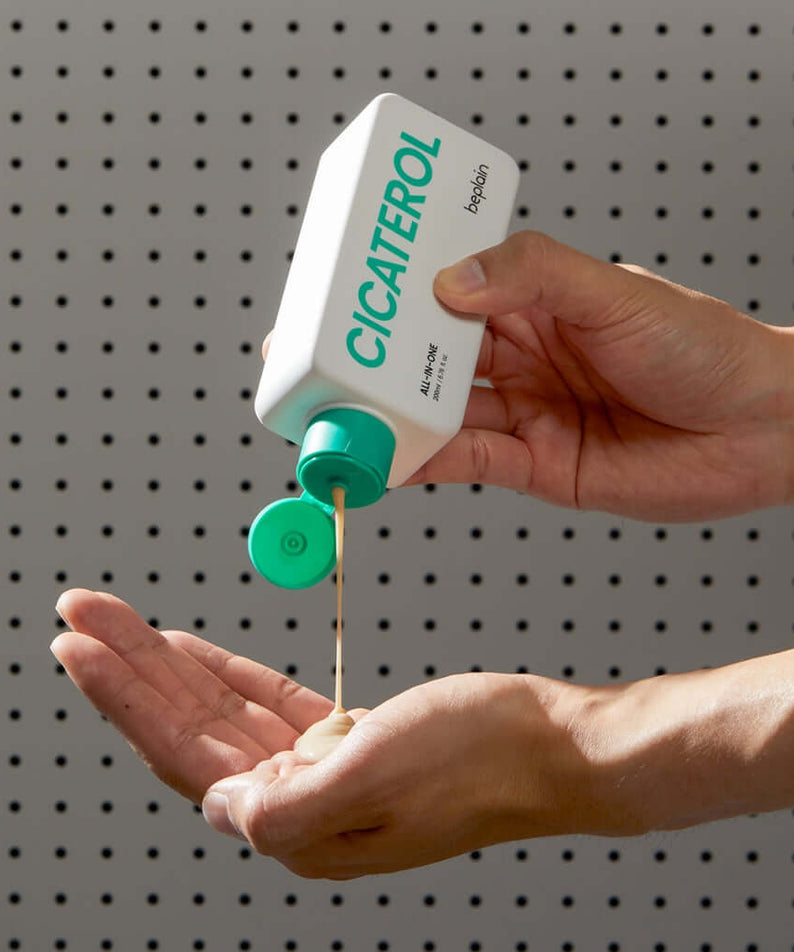 Person applying BEPLAIN Cicaterol All-in-one skincare product to hand for smooth skin.