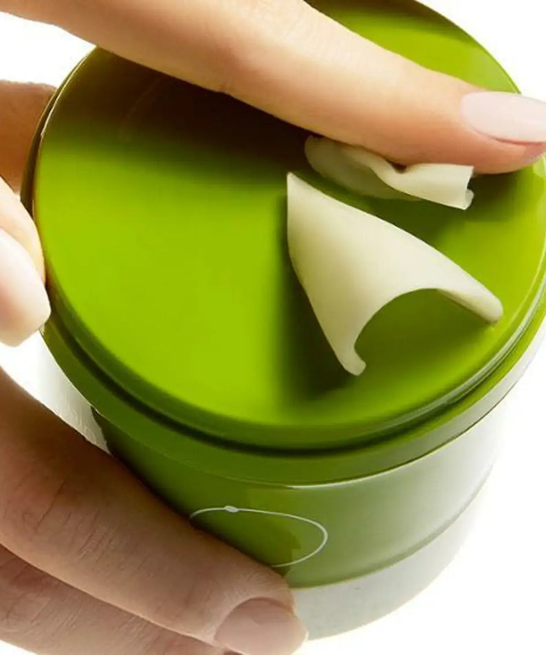 Hand applying BEPLAIN Green Bean Pore Grinding Cleansing Balm from a green container, showcasing its smooth texture.