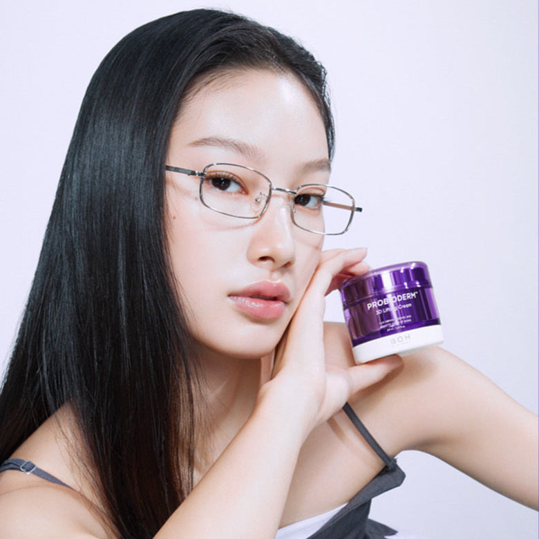 A woman holding a jar of BIO HEAL BOH Probioderm 3D Lifting Cream 50ml, showcasing its packaging against a neutral background.