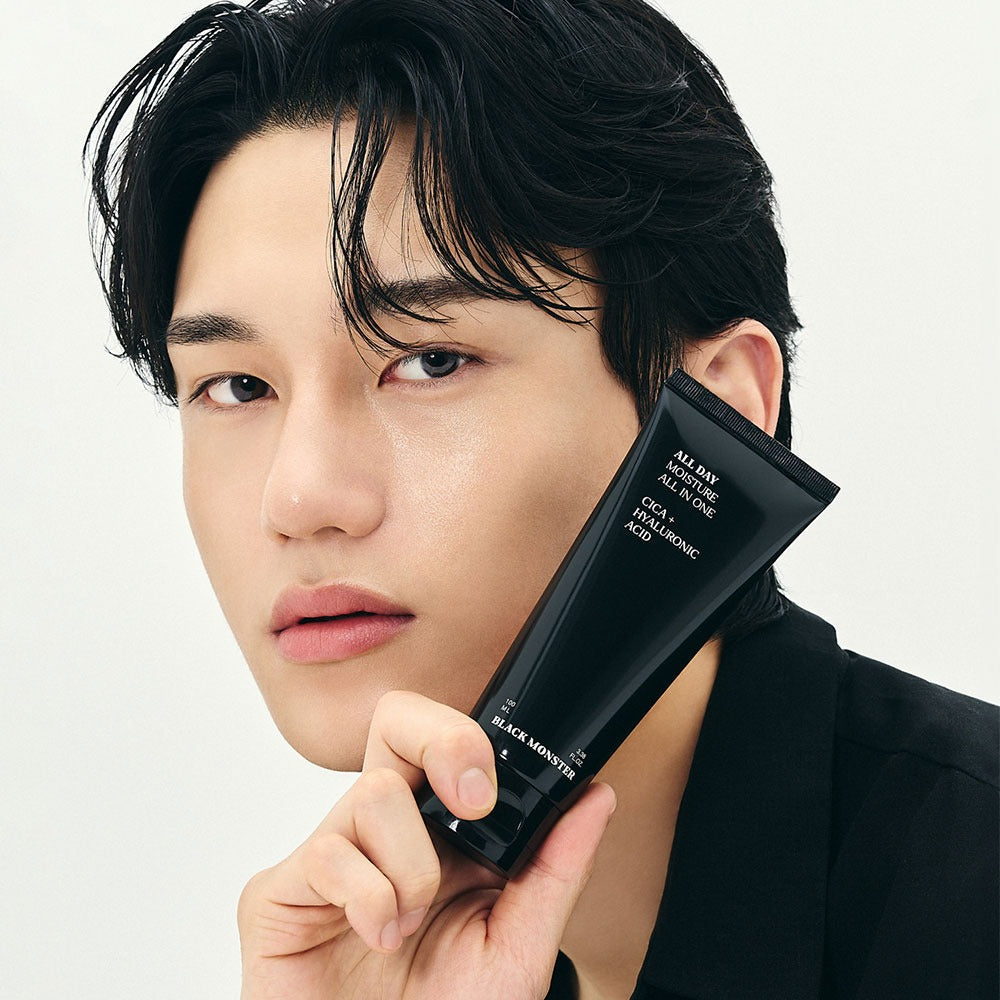 Gentleman Korea product shot: BLACK MONSTER All-Day Moisturizing All-in-One held by male model, sleek black tube for men’s Korean skincare