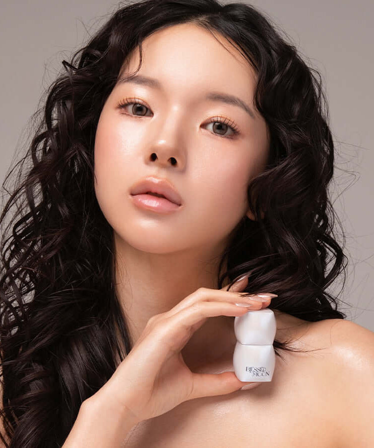 Model holding BLESSED MOON Veil Melting Glass Highlighter showcasing radiant skin