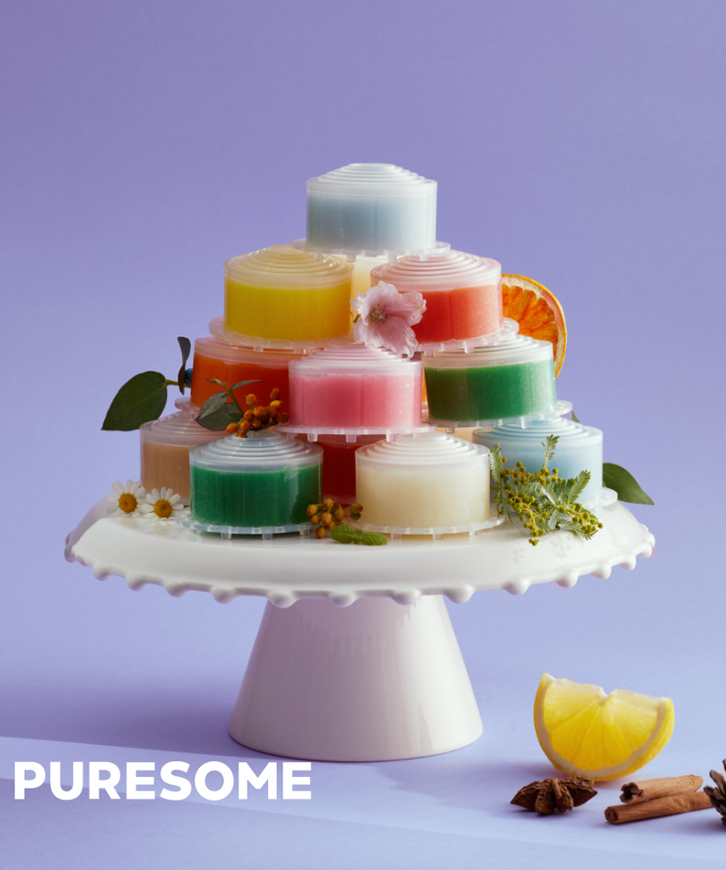 Colorful stacked shower filters on a cake stand by BODYLUV Vita Pure Filter, featuring flowers, citrus, and natural spices.