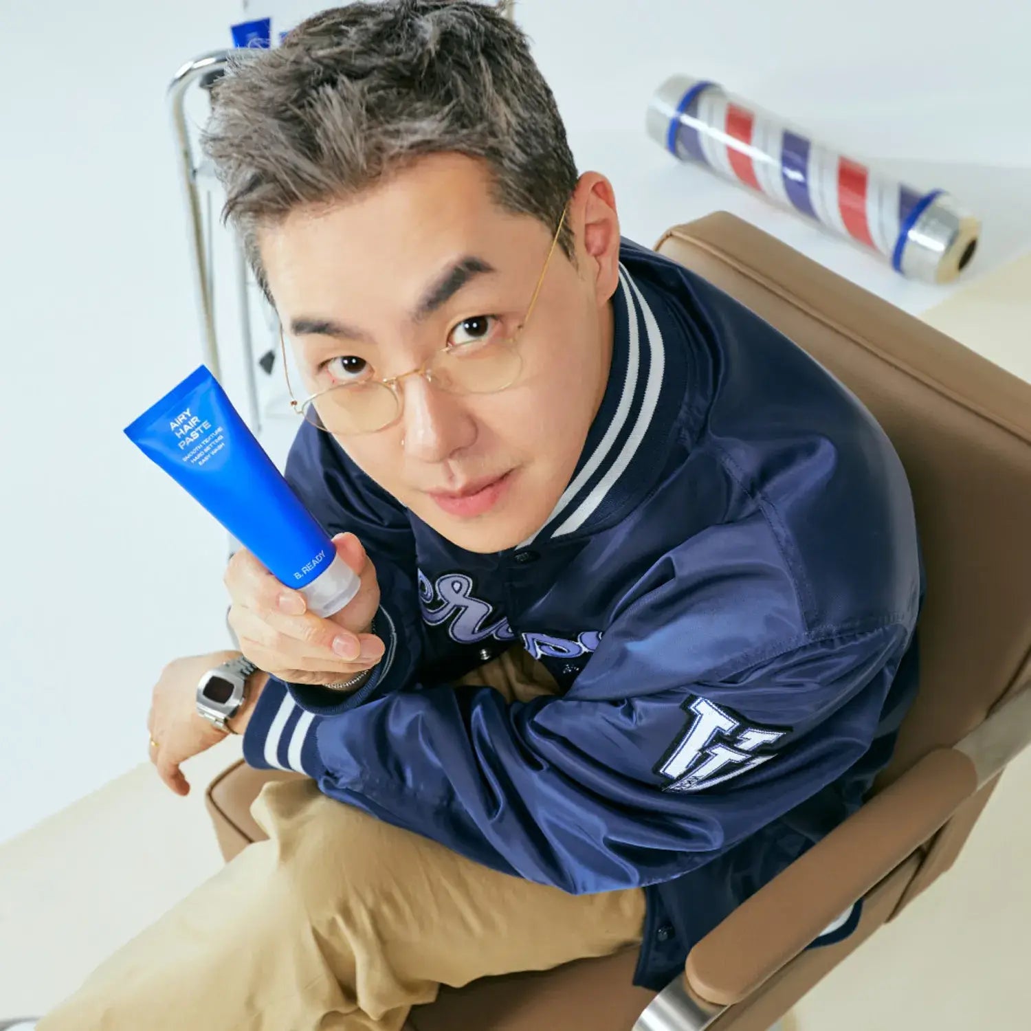 B.READY Airy Hair Paste 80g held by stylish Korean gentleman in barber chair — Gentleman Korea product shot for men’s hairstyling