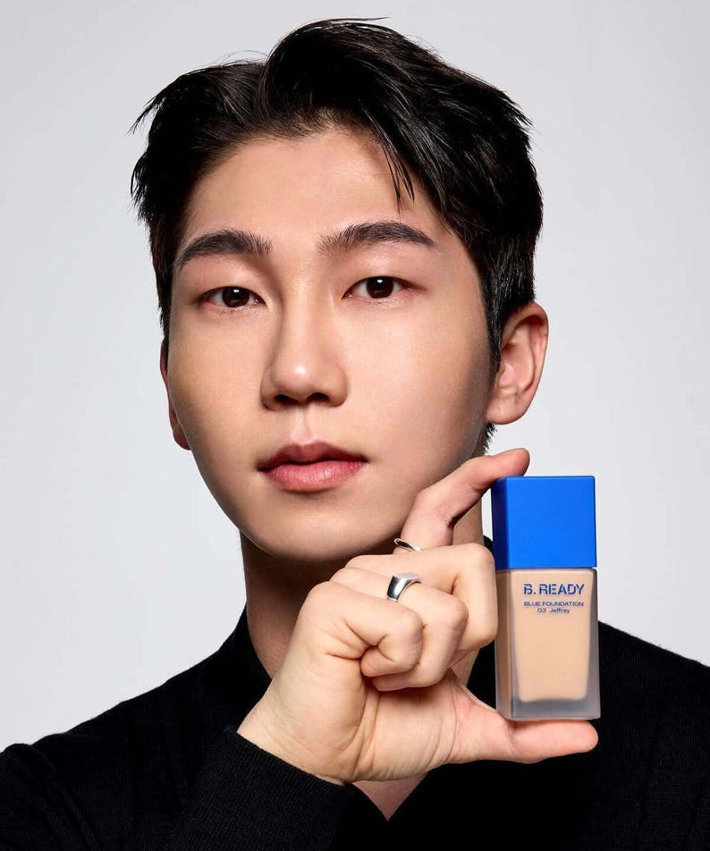 Gentleman Korea model holding B.READY Blue Foundation bottle with blue cap, natural men’s makeup for a polished gentleman look