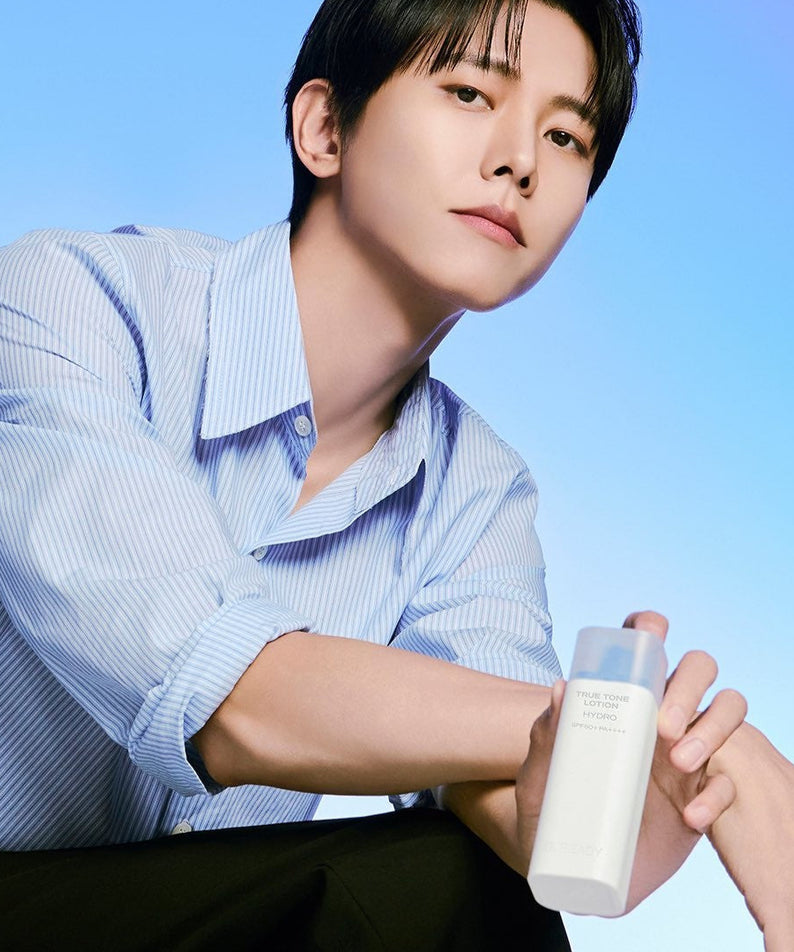 B.READY True Tone Lotion 2.0 40ml held by a well-groomed man in a blue shirt, Gentleman Korea Korean skincare for men, product-focused lifestyle shot
